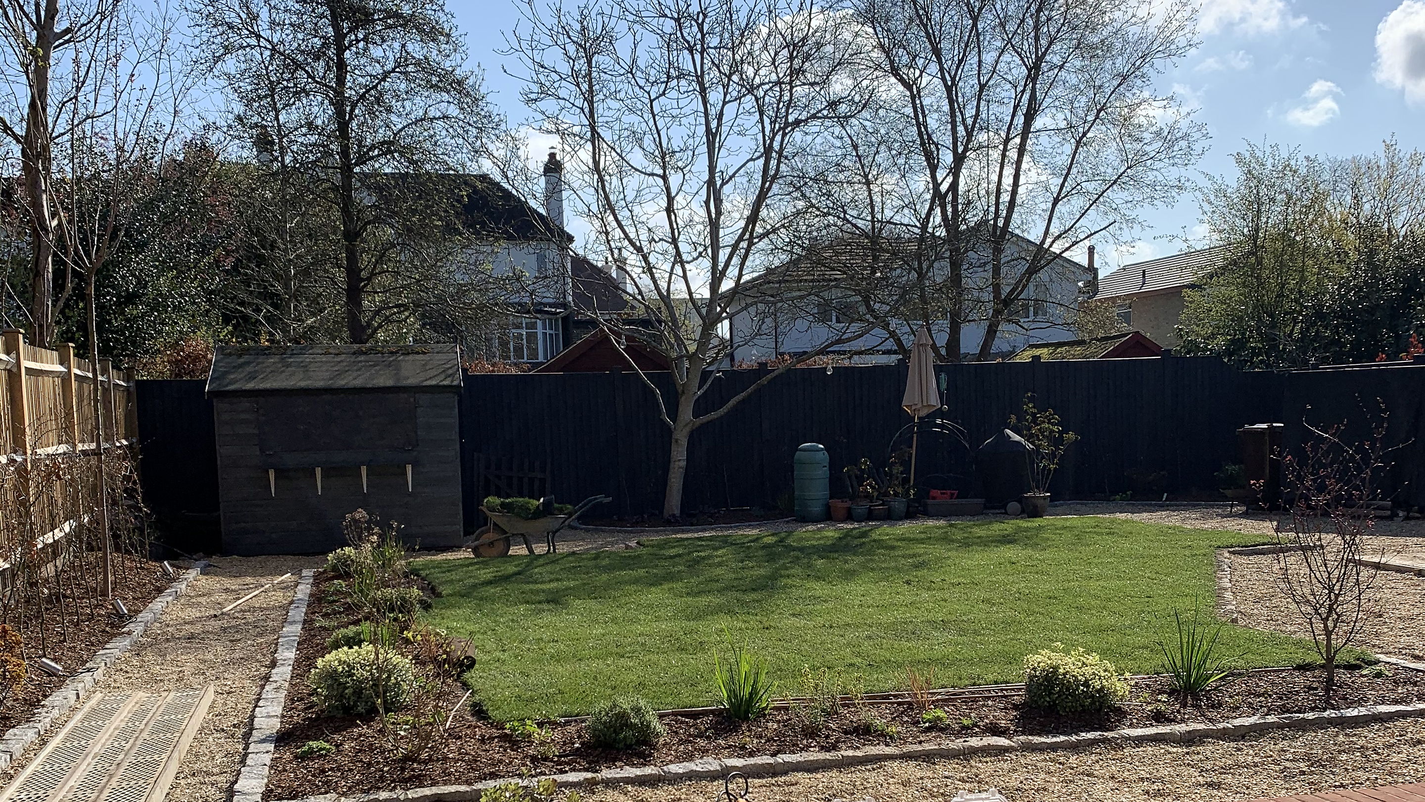 Finished garden with a raised brick bed, lawn and a paved terrace